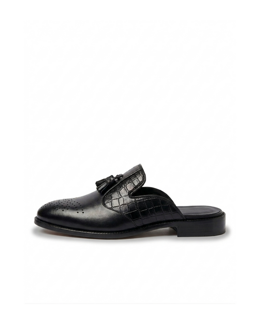 ⁠Side profile of RENARD NOIR black leather tassel mules showing croc texture and brogue toe